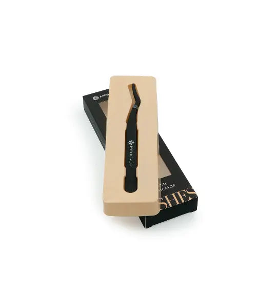 Applicateur de faux cils noir avec design ergonomique, présenté dans un coffret ouvert. Assure une application précise et rapide des faux cils.