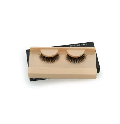 Faux cils « Extreme Gaze » présentés dans un étui beige. Faciles à appliquer et réutilisables, ils subliment le regard avec un effet volumineux.