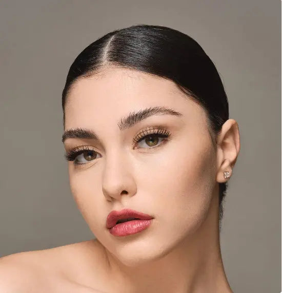 Femme portant les faux cils « Extreme Gaze » pour un regard intense et sophistiqué. Ces faux cils réutilisables apportent volume et élégance.